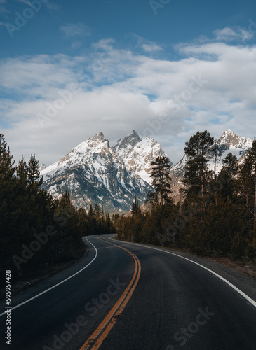 A winding paved road to Grand Targhee ski area looks up toward the summit of the Grand Teton in Wyoming.