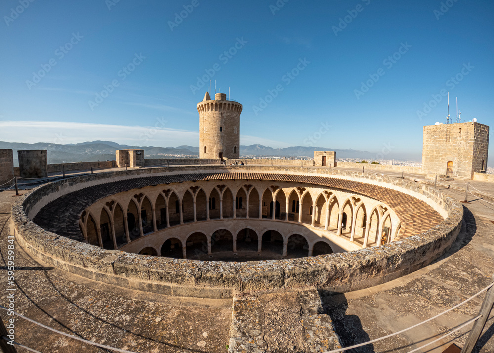 Il castello di Bellver, situato in cima a una collina vicino a Palma di Maiorca, è uno dei pochi castelli gotici circolari in Europa. Particolare del cortile interno circolare - obrazy, fototapety, plakaty 