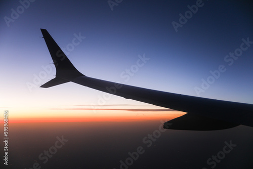 An airplane view of the wing against the sunset sky symbolizes freedom, adventure, and perspective. It represents the joy of travel and the beauty of the world