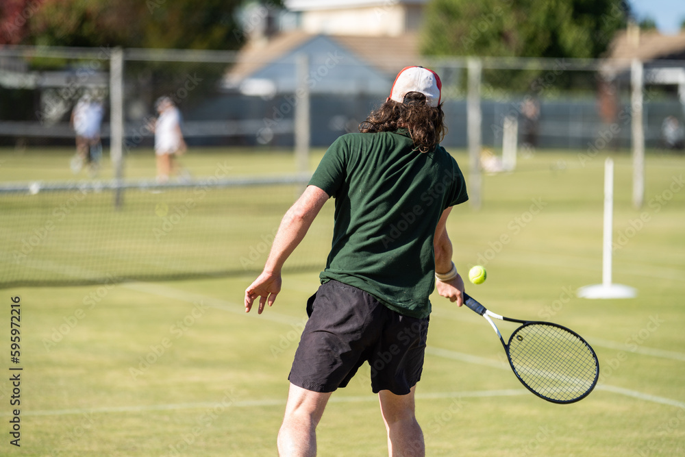 Amateur playing tennis at a tournament and match on grass in Melbourne, Australia	