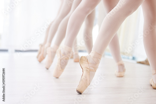 Being a dancer takes commitment. a group of ballerina dancers practicing a routine in their pointe shoes.
