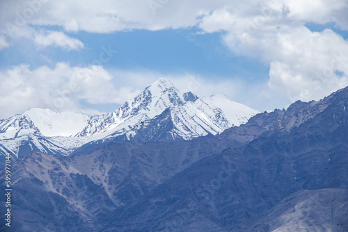 Fototapeta Naklejka Na Ścianę i Meble -  A hazy shot of snow-capped Himalaya peaks with cloudy blue sky.