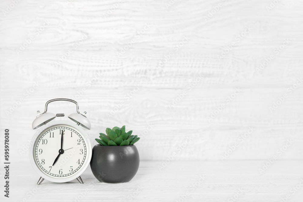 Front view white desk with alarm clock, houseplant and copy space. Morning background banner with free space for text. Minimalistic concept, workspace, time to work. Blank workplace. Office mock-up Front view white desk with alarm clock, houseplant and copy space. Morning background banner with free space for text. Minimalistic concept, workspace, time to work. Blank workplace. Office mock-up