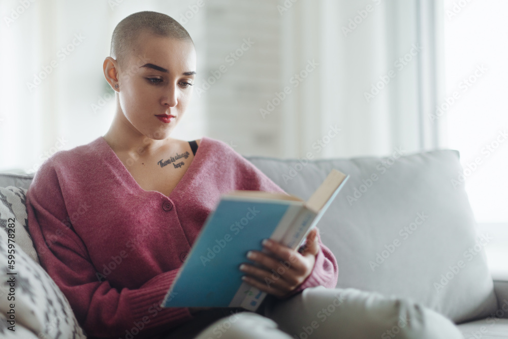 Young woman with cancer reading book, cancer awareness concept. Young woman with cancer reading book, cancer awareness concept.