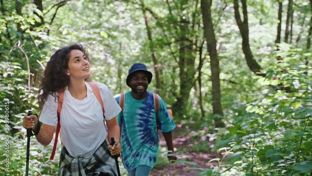 Smiling relaxed couple hiking trekking together in forest trail. Smiling relaxed couple hiking trekking together in forest trail.