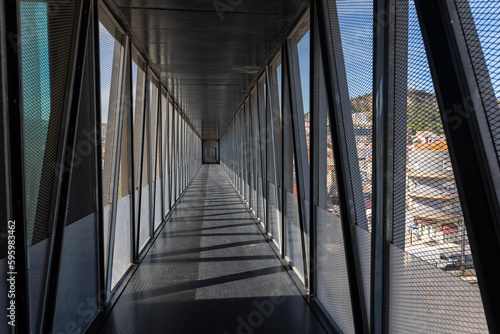 Walking on modern bridge in european town - a person's POV