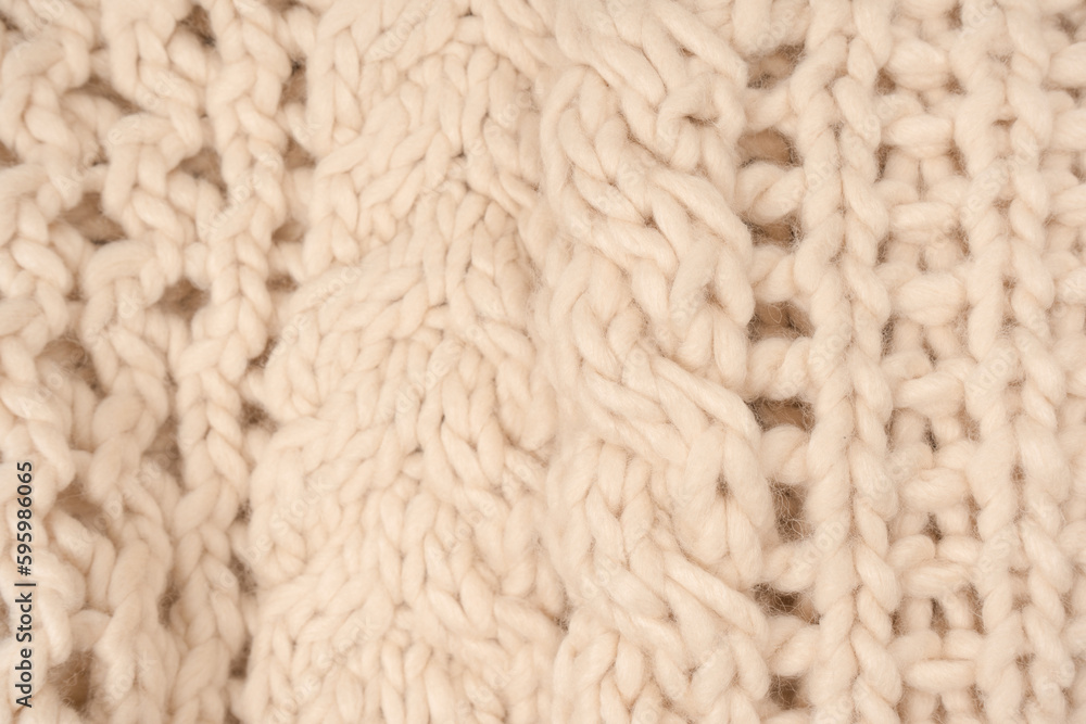A fragment of beige knitted fabric, knitted from white sheep wool. A fragment of beige knitted fabric, knitted from white sheep wool.