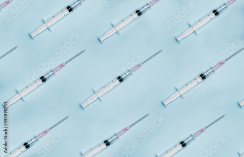 Creating a safer space one vaccine at a time. a group of syringes against a blue background.
