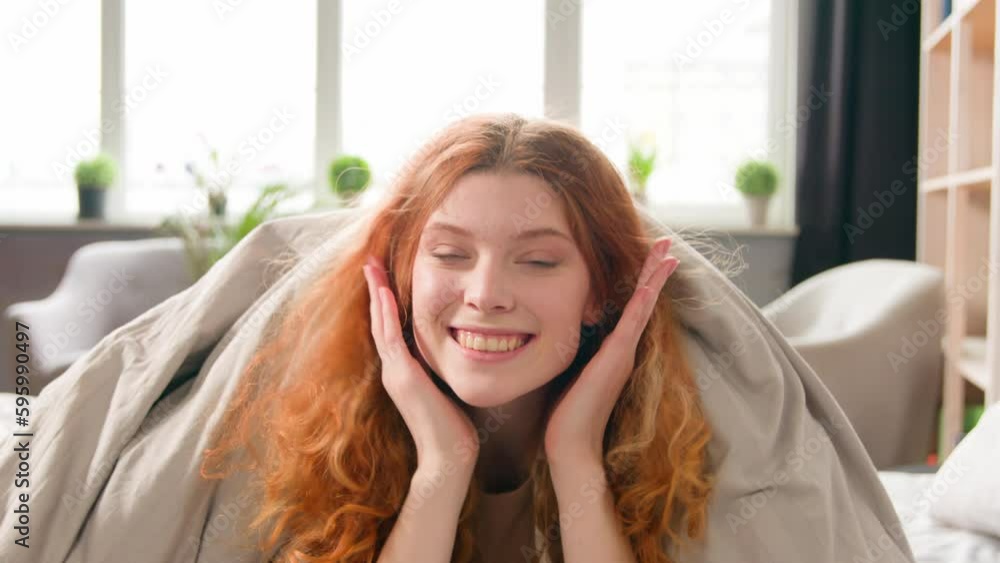 Caucasian happy girl smiling peep out from under blanket appear playful hiding in comfortable white bed sheet send air kiss in bedroom at morning carefree funny seductive woman smile sending love Caucasian happy girl smiling peep out from under blanket appear playful hiding in comfortable white bed sheet send air kiss in bedroom at morning carefree funny seductive woman smile sending love