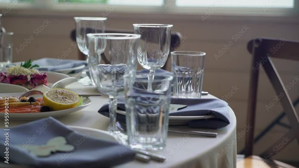 Served tables for a holiday in a restaurant. Glasses, plates, cutlery, napkins. Wedding decor, celebration dinner or party, reception indoors. No food. Served tables for a holiday in a restaurant. Glasses, plates, cutlery, napkins. Wedding decor, celebration dinner or party, reception indoors. No food.