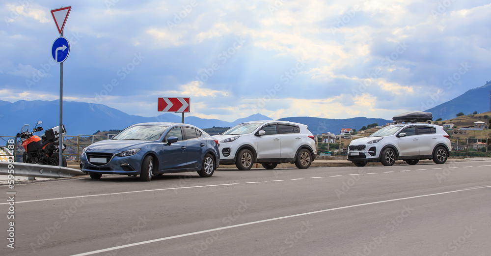 Cars parked on the roadside in front of mountain landscape