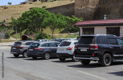 Cars in the parking lot near the walls of an ancient fortress