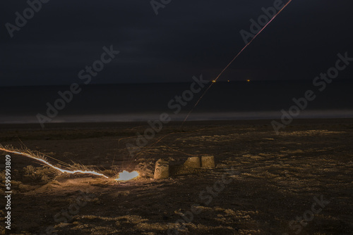 An exploding firecracker on the sand against the background of the sea