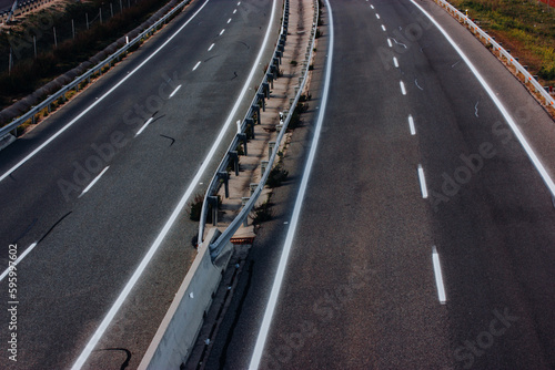 Aerial view of a paved highway road with white markings seen from above. Road repair  travel concept. Separating lanes on the road  a baffle for the safe movement of cars.