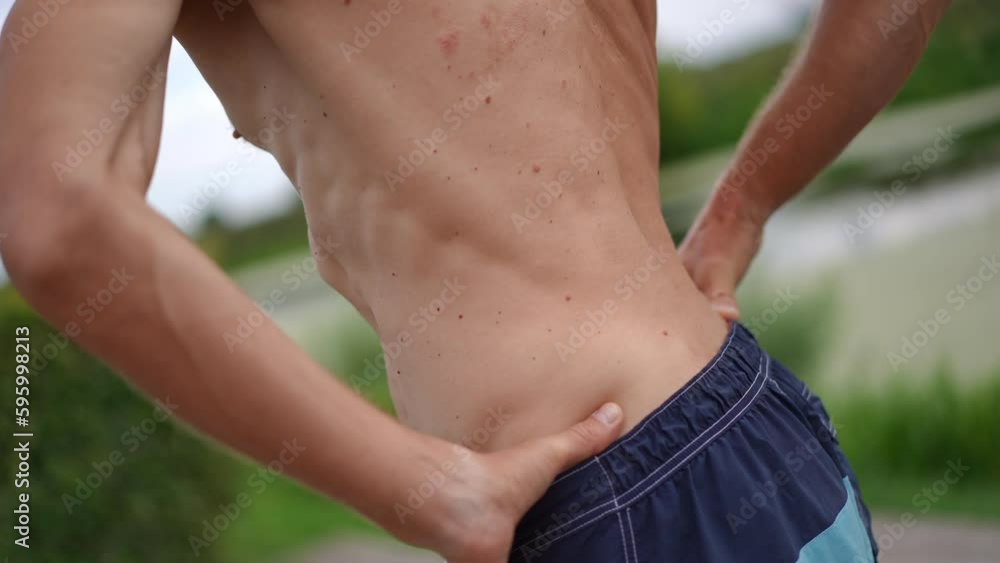Shirtless torso of sportive man turning warming up exercising outdoors on spring summer day. Unrecognizable Caucasian sportsman training in park in slow motion Shirtless torso of sportive man turning warming up exercising outdoors on spring summer day. Unrecognizable Caucasian sportsman training in park in slow motion