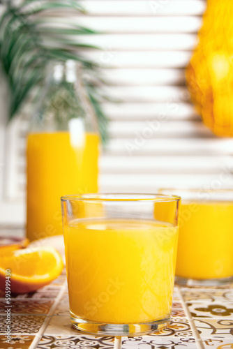 Fresh orange juice on table with slices fruits.