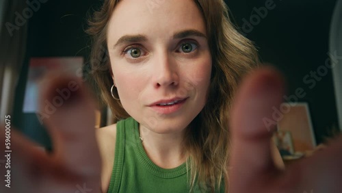 Amazed lady zooming fingers screen at home web camera view. Surprised woman face