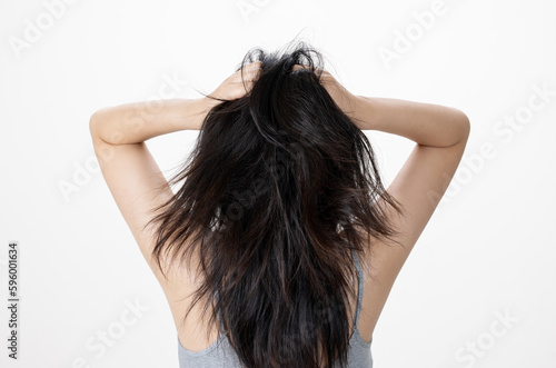 Close-up of hands holding damaged and tousled hair, back view