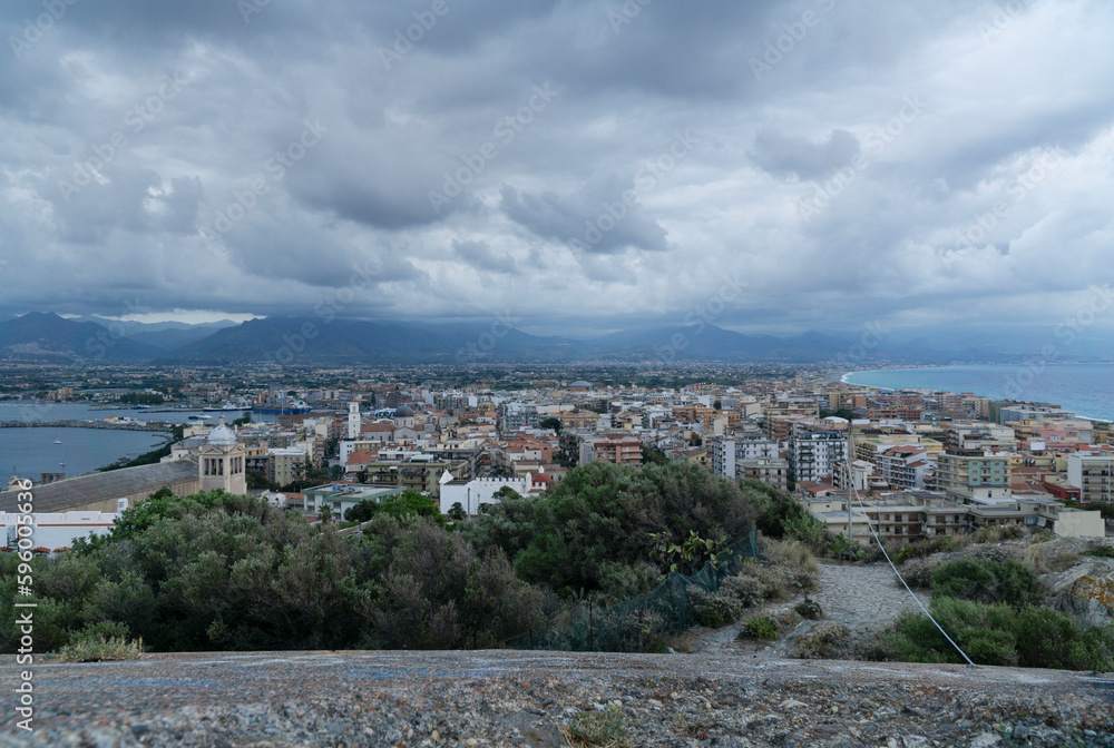 Beautiful milazzo city panoramic dusk view from milazzo castle viewpoint with cloudy sky and messina mountains at background