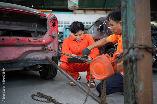 To return the automobile body to its former shape, an auto repair mechanic uses a machine to pull the car body caused by a heavy collision until it is deformed.