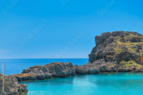 View from the beach of St. Paul's bay near the city of Lindos, clear blue sky and emerald sea, Rhodes island, Greek islands of the Dodecanese archipelago. Holidays and travel around the islands