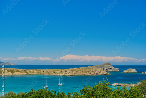 View of sailboats in the bay near the ancient city of Lindos on the Greek island of Rhodes, view of the Aegean Sea, the islands of the Dodecanese archipelago, Europe
