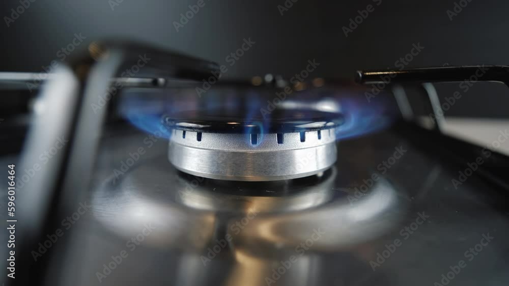 Gas ignition on the burner, close-up. Natural gas burning on kitchen gas stove