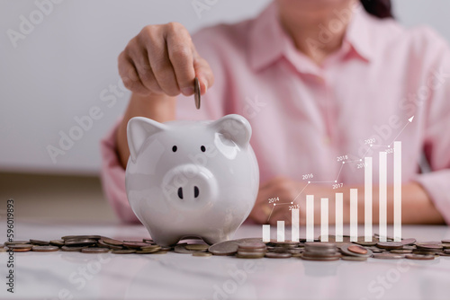 business woman putting coin on the piggybank and icon graph, saving, charity, finance plan and investment, fundraising, superannuation,  financial crisis concept.