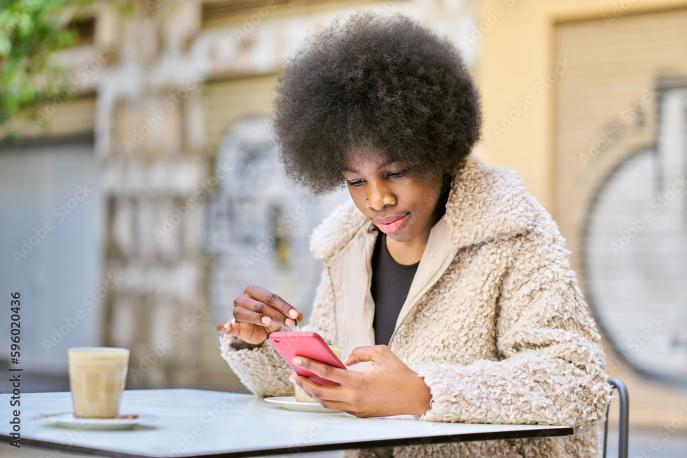 Focused black woman using smartphone in cafe Focused black woman using smartphone in cafe