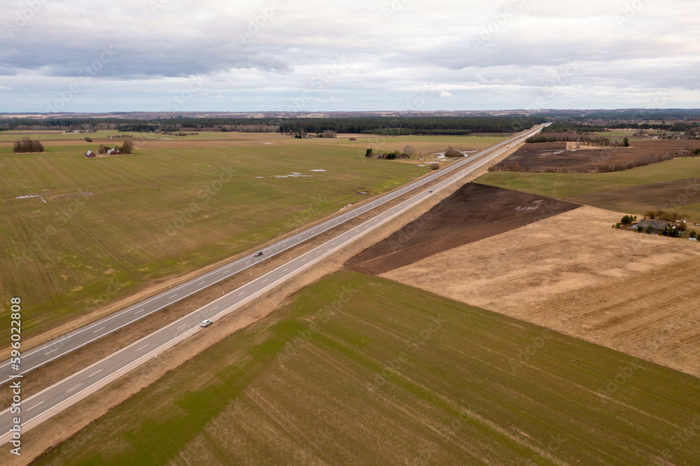 Drone photography of highway in rural setting surrounded by agricultural fields