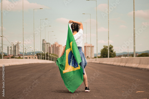 Mulher em uma rua com a bandeira do Brasil photo