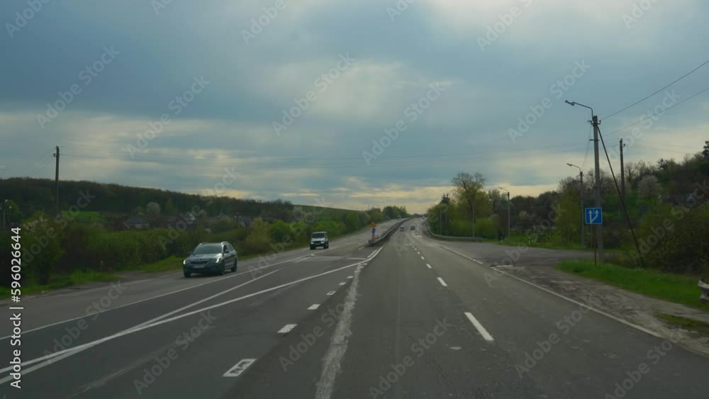 Driving along a country highway. Front view from the car window , surrounding scenery and other cars Driving along a country highway. Front view from the car window , surrounding scenery and other cars