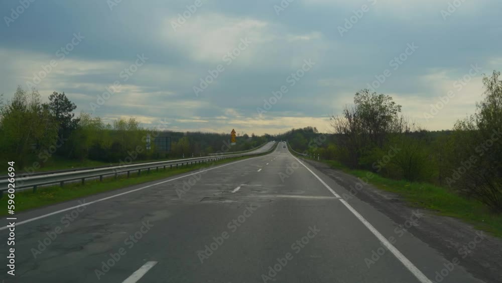 Driving along a country highway. Front view from the car window , surrounding scenery and other cars Driving along a country highway. Front view from the car window , surrounding scenery and other cars