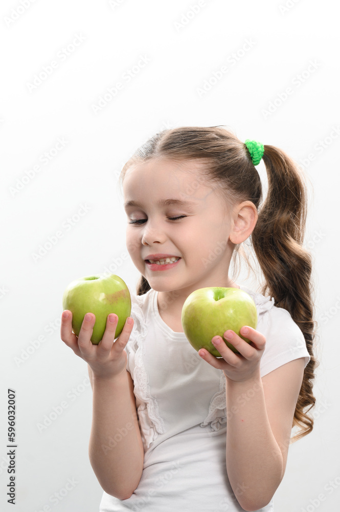 a little girl holds two green apples in her hands on a white background a little girl holds two green apples in her hands on a white background