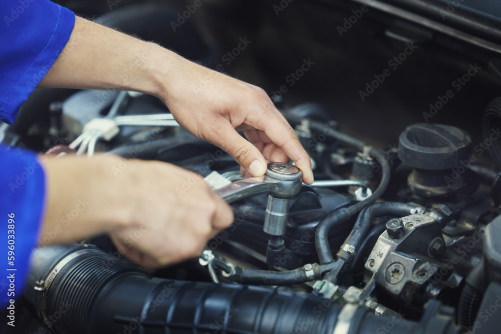 Getting to grips with your engine. High angle shot of an unrecognizable male mechanic working on the engine of a car during a service. Getting to grips with your engine. High angle shot of an unrecognizable male mechanic working on the engine of a car during a service.