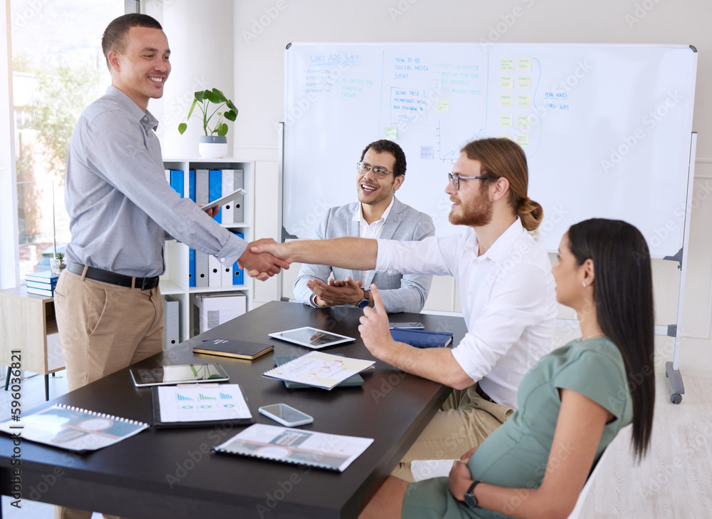 Welcome to the team. a diverse group of businesspeople shaking hands during a meeting in the office.