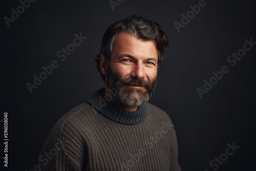 Portrait of a bearded man in a sweater on a dark background