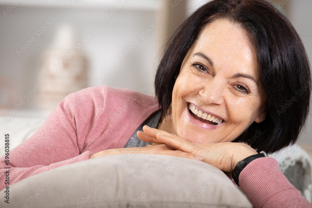 portrait of smiling senior woman relaxing on couch at home portrait of smiling senior woman relaxing on couch at home