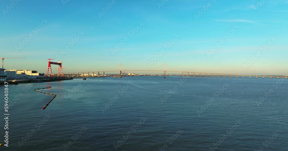 Flying above the road of cable-stayed French bridge. Amazing sunrise. Aerial view of the Saint Nazaire Bridge a cable stayed bridge spanning the Loire river, France Flying above the road of cable-stayed French bridge. Amazing sunrise. Aerial view of the Saint Nazaire Bridge a cable stayed bridge spanning the Loire river, France