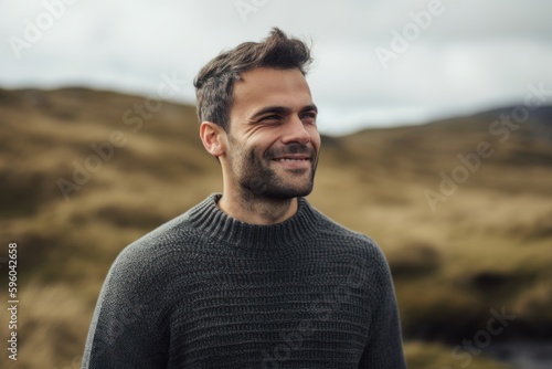 Portrait of a handsome young man smiling outdoors in the countryside.