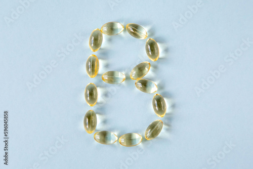 The transparent capsules are shaped like the letter B on a blue background. photo