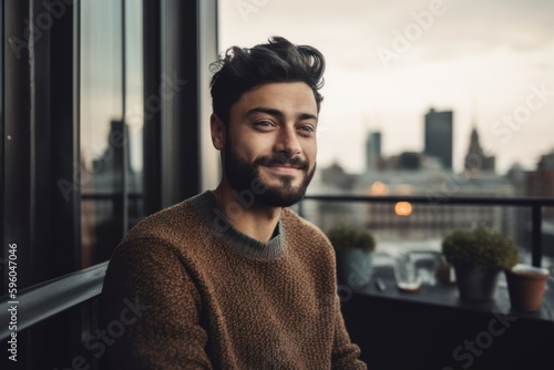 Portrait of a handsome young man in a cafe with city view