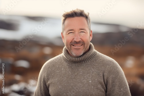 Portrait of a handsome middle-aged man in a warm sweater on the beach © Robert MEYNER