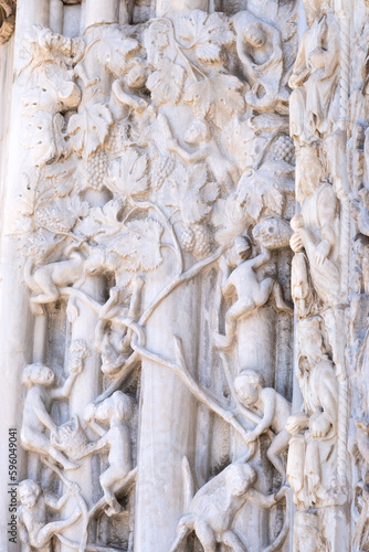 Marble details on facade of Messina Cathedral or Duomo di Messina  Sicily  Italy. Reliefs on wall picturing human figures harvesting grapes. Decorative elements in architecture