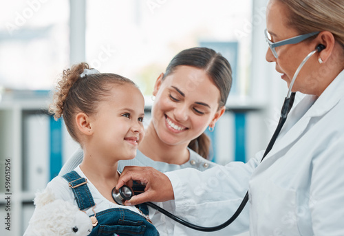 In for a checkup to ensure proper growth and development. a doctor examining a little girl with a stethoscope in a clinic. photo