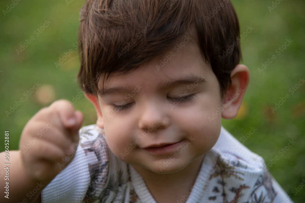 Close-up view of little baby boy playing outdoors. Close-up view of little baby boy playing outdoors.