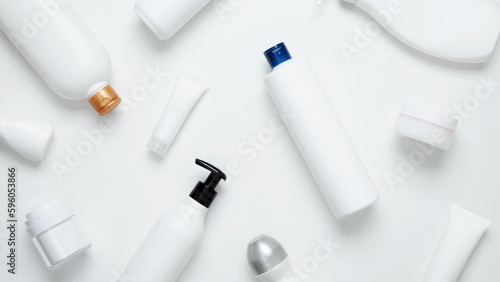 Cosmetic beauty products on white background. Bottles and tubes with branding mock up. Skin care and beauty concept. Top view, flat lay, copy space