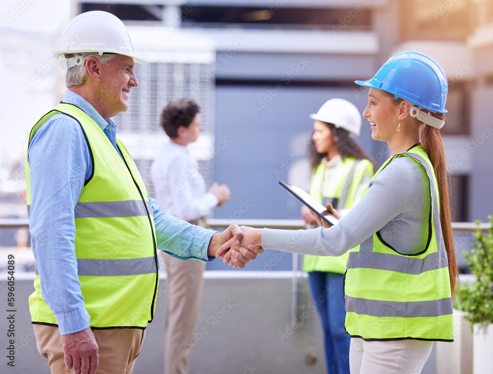 Ready for the electrical. two construction workers shaking hands while standing on a building site. Ready for the electrical. two construction workers shaking hands while standing on a building site.