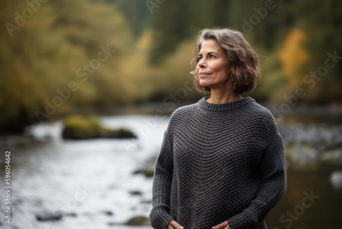 Portrait of a middle-aged woman in a sweater standing by the river