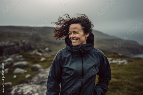 Portrait of a happy woman standing on top of a mountain and laughing